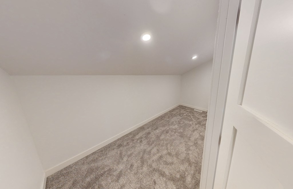 a room with white walls and carpet and a white door