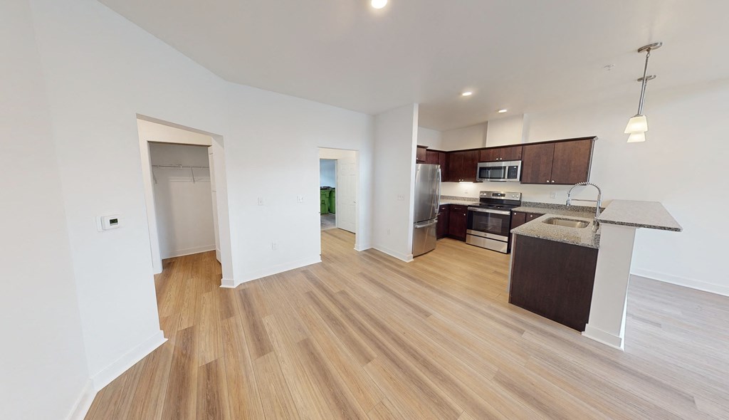 a renovated living room and kitchen with wood flooring and