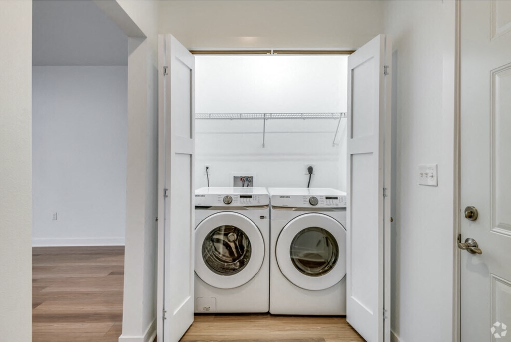 a washer and dryer in a laundry room with a sink and a window