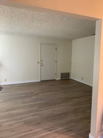a living room with a wooden floor and a white door