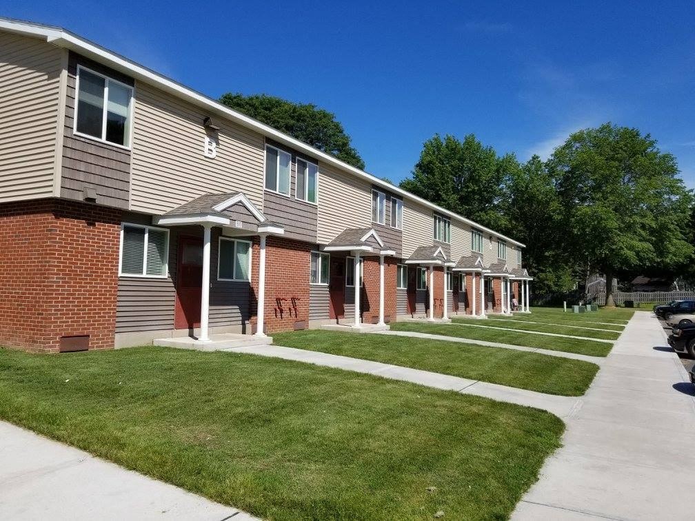 a row of houses on the side of a sidewalk
