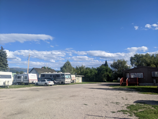 a large gravel parking lot filled with parked rvs and tents