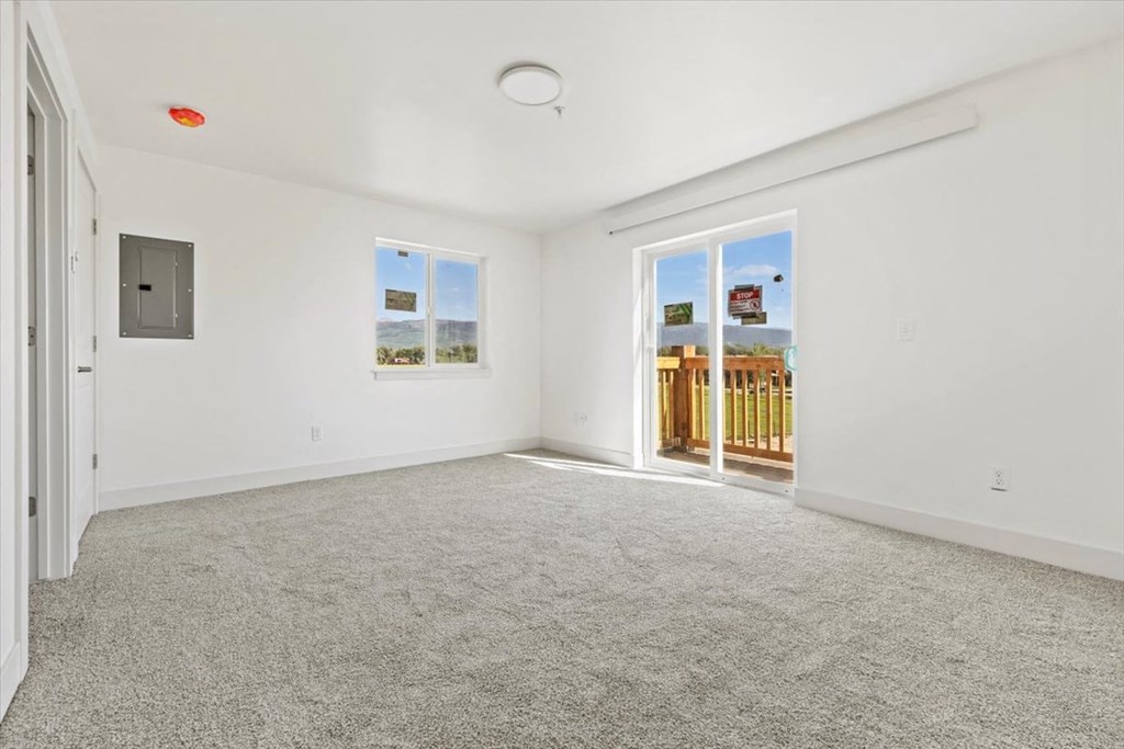 an empty living room with a door to a balcony