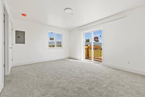 an empty living room with a door to a balcony