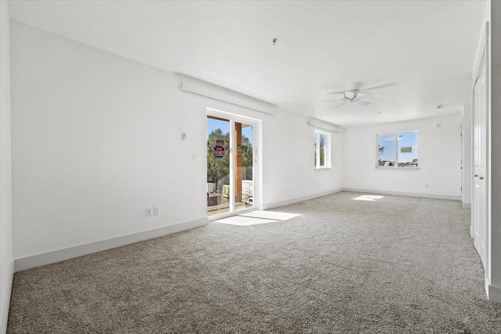 an empty living room with white walls and carpet