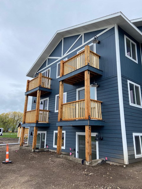 a blue house with two balconies and a cone in front of it