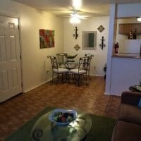 a living room and dining room with a table and chairs