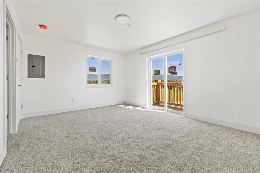 an empty living room with a door to a balcony