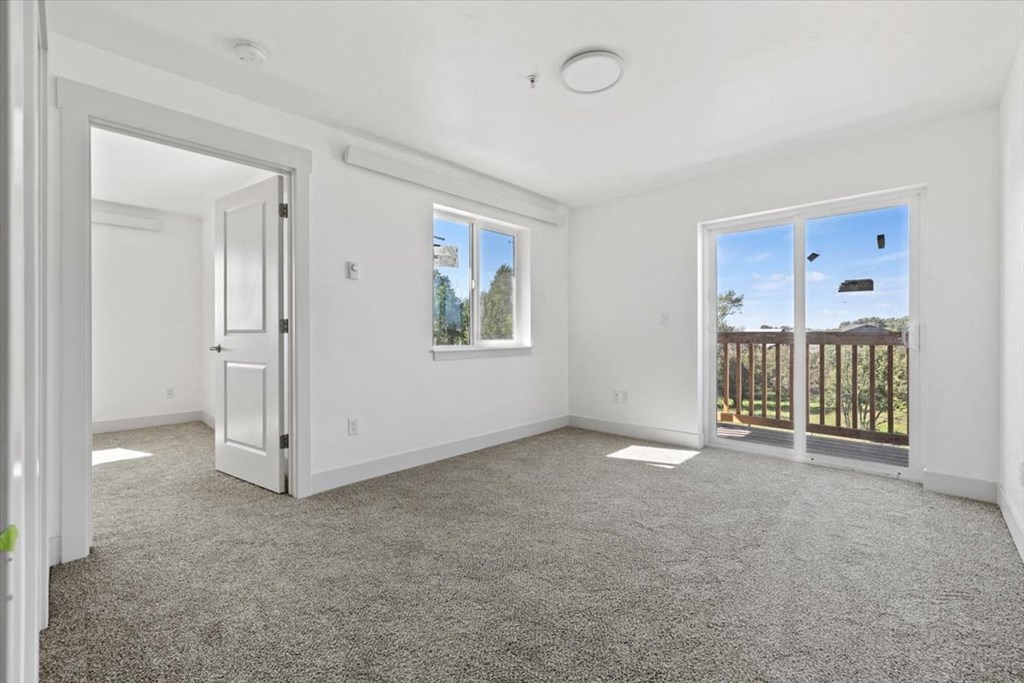 an empty living room with a door to a balcony