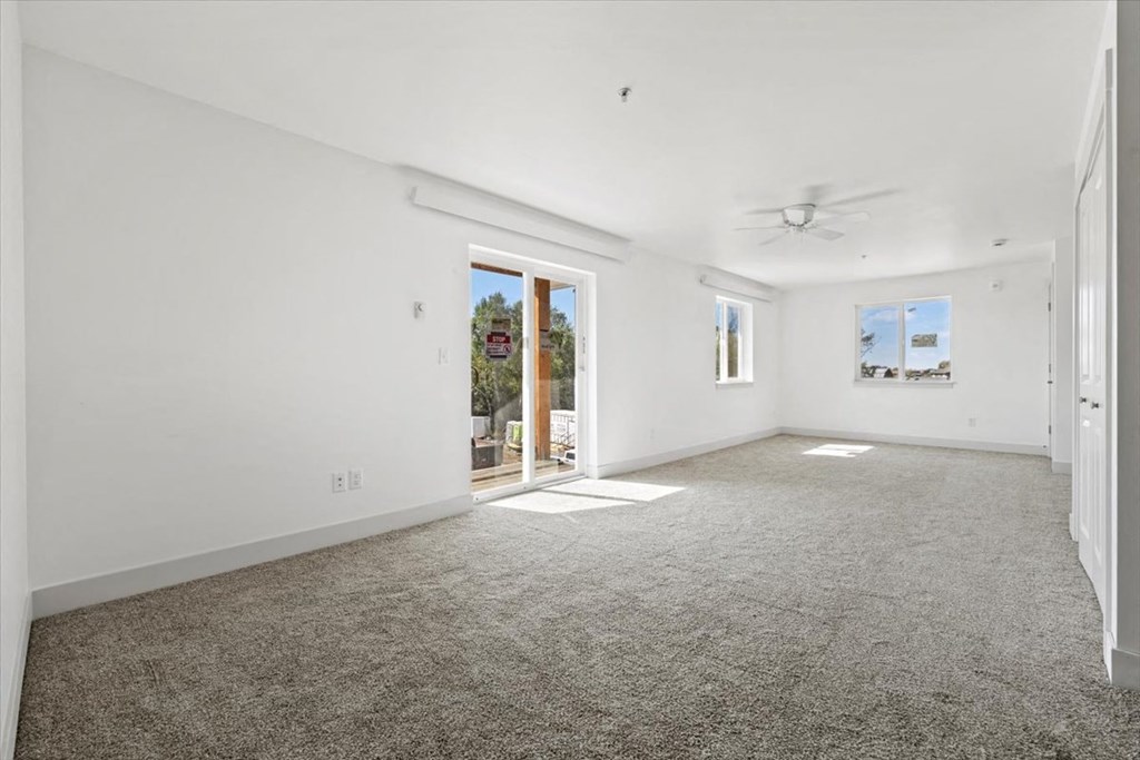 an empty living room with white walls and carpet