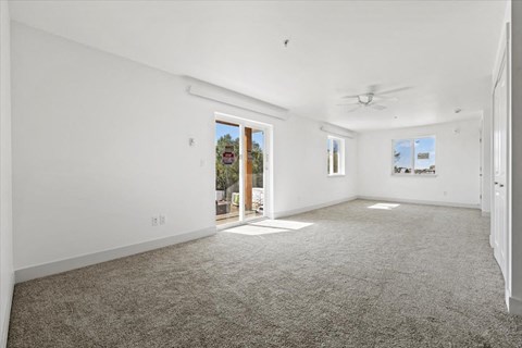 an empty living room with white walls and carpet