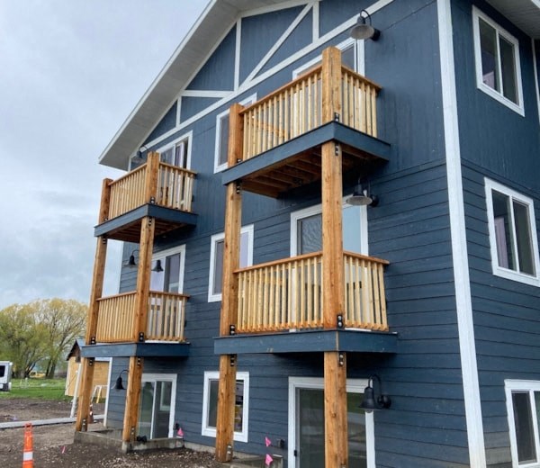 three balconies on the side of a blue house