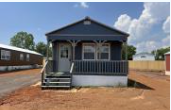 A small blue house with a porch and a white door.