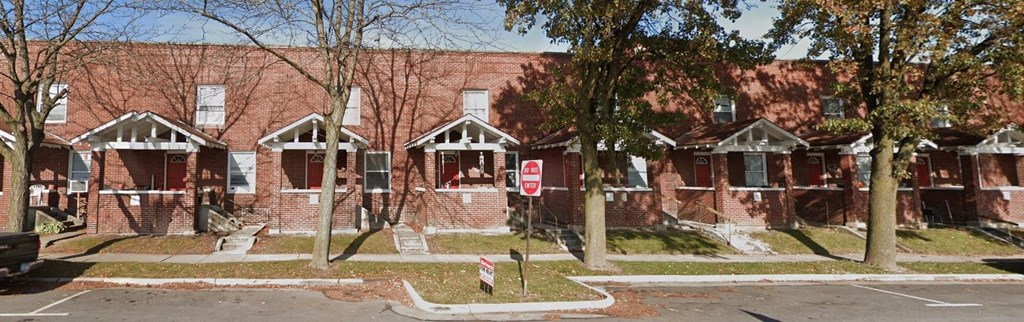 a red brick building with a stop sign in front of it