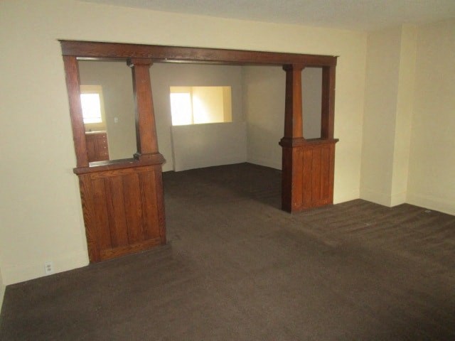 an empty living room with two wooden doors