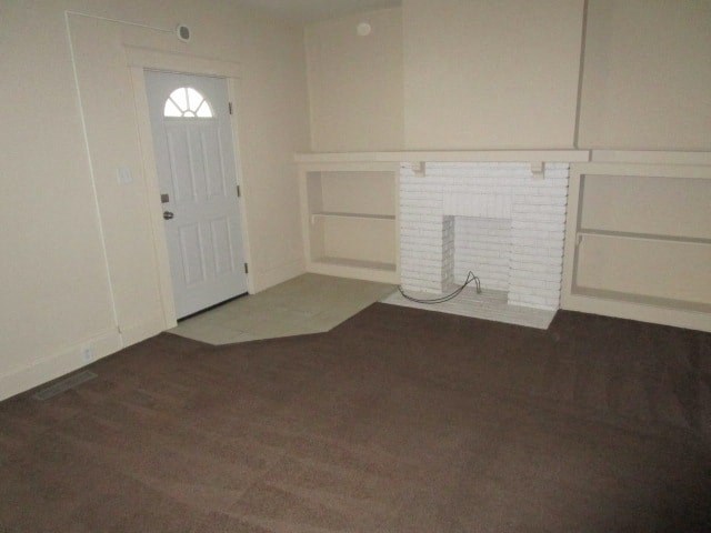 an empty living room with a fireplace and a door