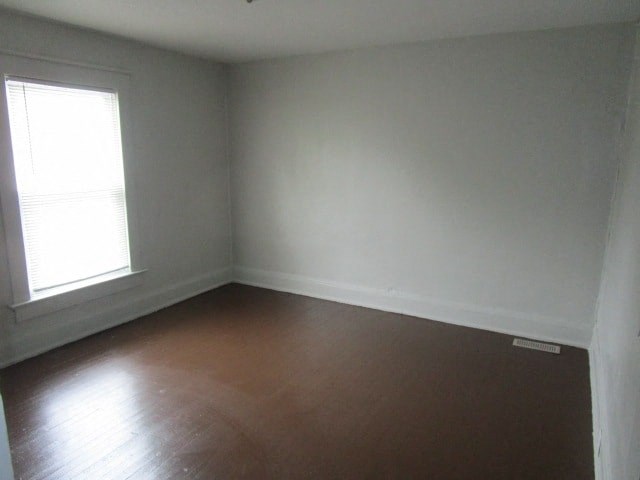an empty room with a wooden floor and a window