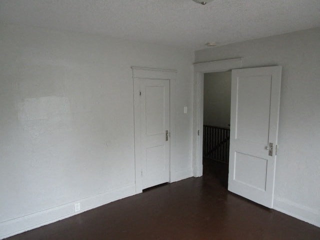 an empty living room with white walls and two doors