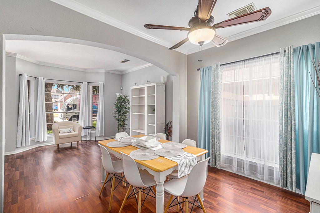 a dining room with a table and chairs and a ceiling fan