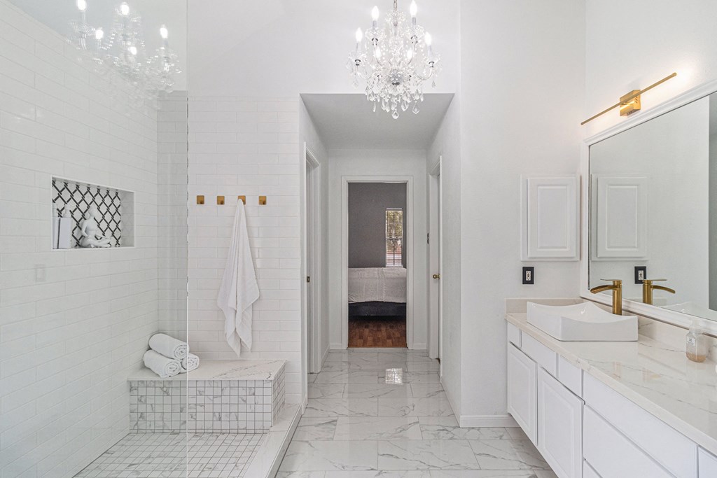 a white bathroom with a tub and a sink and a shower