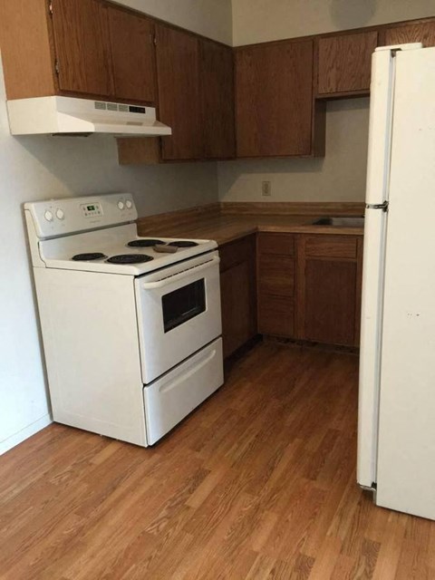 an empty kitchen with a stove and a refrigerator