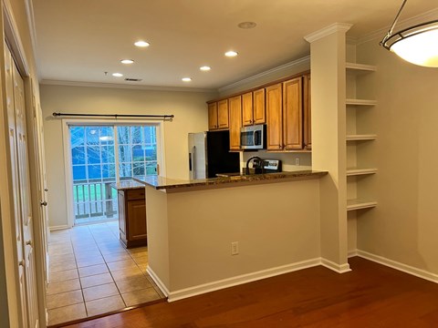 A kitchen with wooden cabinets and a black refrigerator.