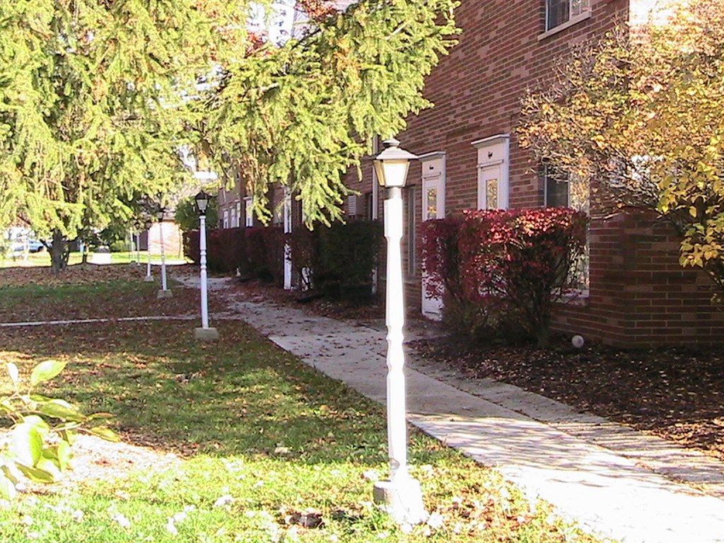 a sidewalk in front of a brick house