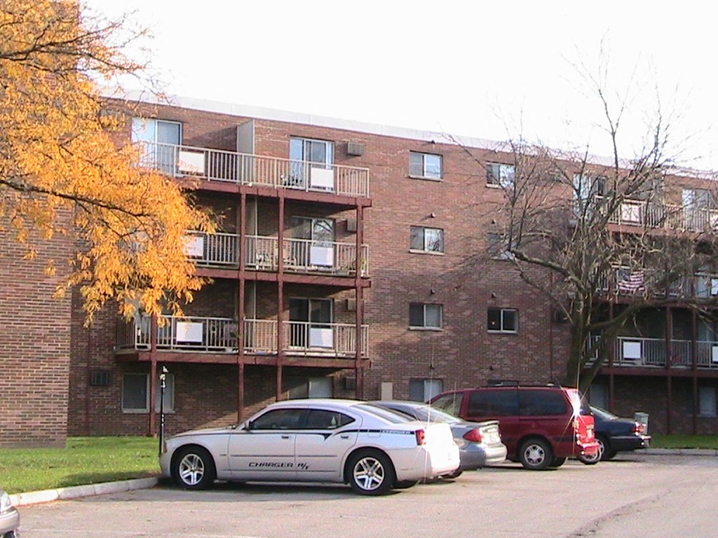 a brick apartment building with cars parked in front of it