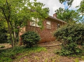 a brick house with a yard and trees