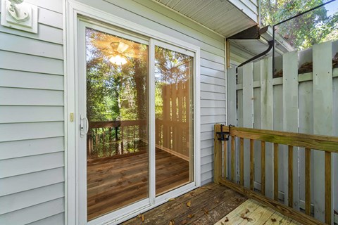 A screened door with a view of trees and sunlight.