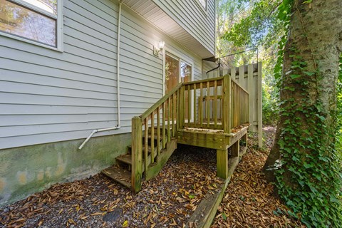 A wooden staircase with a railing leads up to a house.