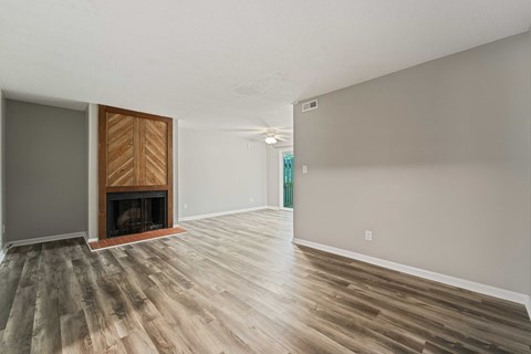 A room with a fireplace and wood flooring.