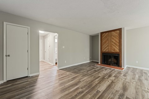 A room with a fireplace and wood flooring.