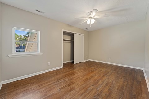 A room with a wooden floor and a ceiling fan.