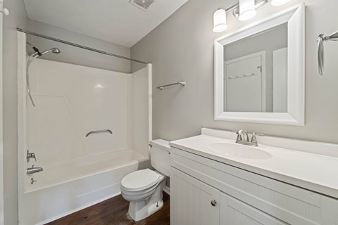 A white bathroom with a toilet, sink, and bathtub.