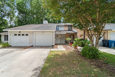 A two-story house with a garage and a driveway.