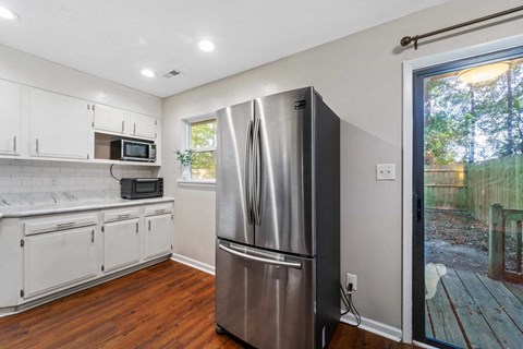 a kitchen with a stainless steel refrigerator and a window