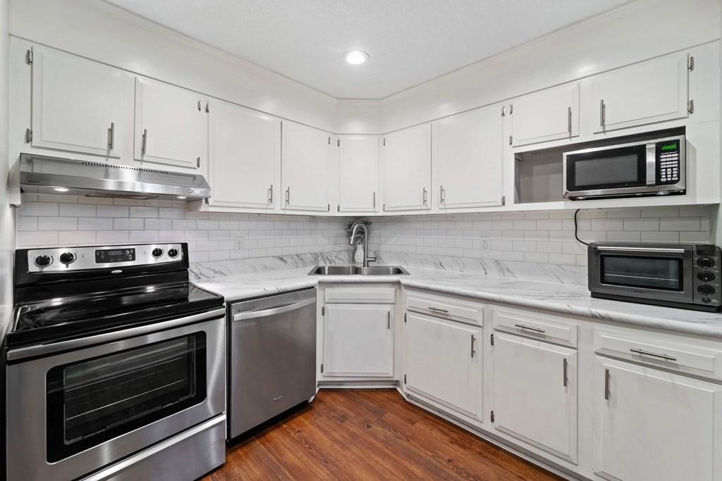 A kitchen with white cabinets and stainless steel appliances.
