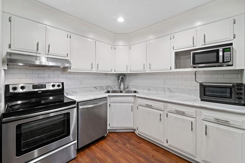 A kitchen with white cabinets and stainless steel appliances.