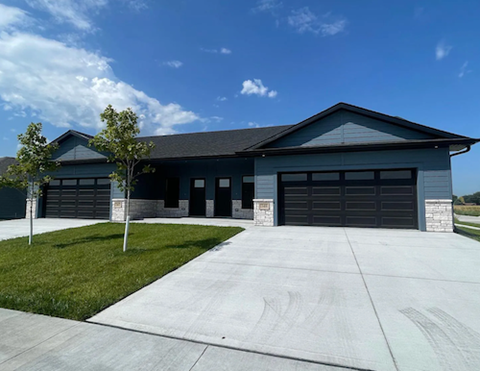 A two-story building with a garage door and a driveway in front.