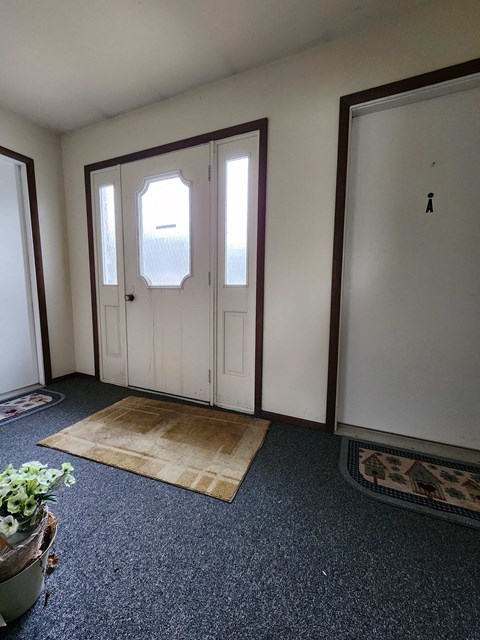 a living room with a white door and a carpet