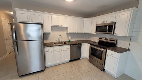 a kitchen with stainless steel appliances and white cabinets
