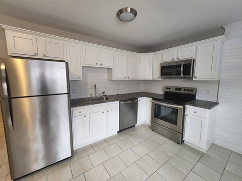 a kitchen with stainless steel appliances and white cabinets