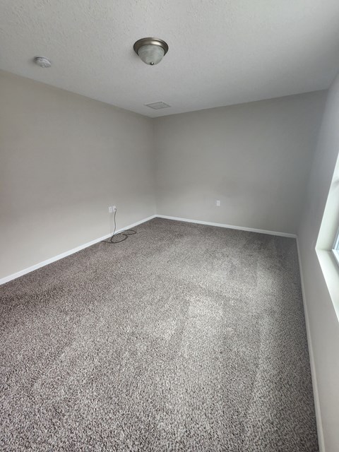 an empty room with a carpeted floor and white walls