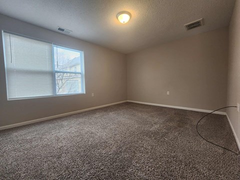 an empty room with carpet and a window