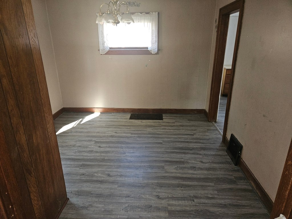 an empty room with wood floors and a window