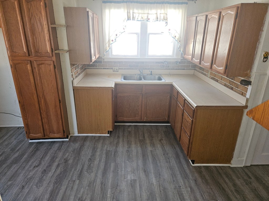 an empty kitchen with wooden cabinets and a sink