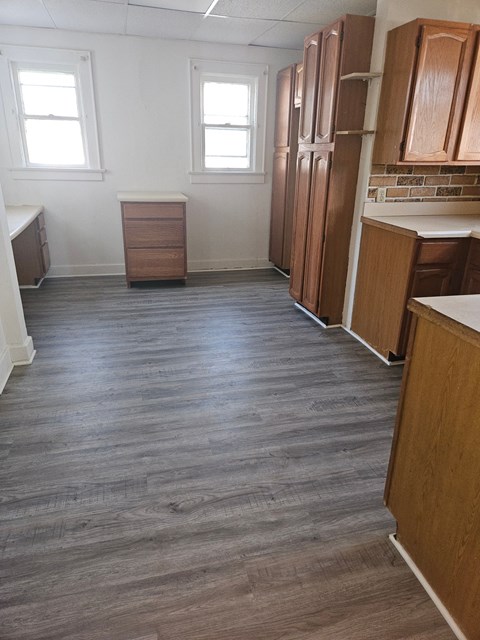an empty kitchen with wooden floors and wooden cabinets