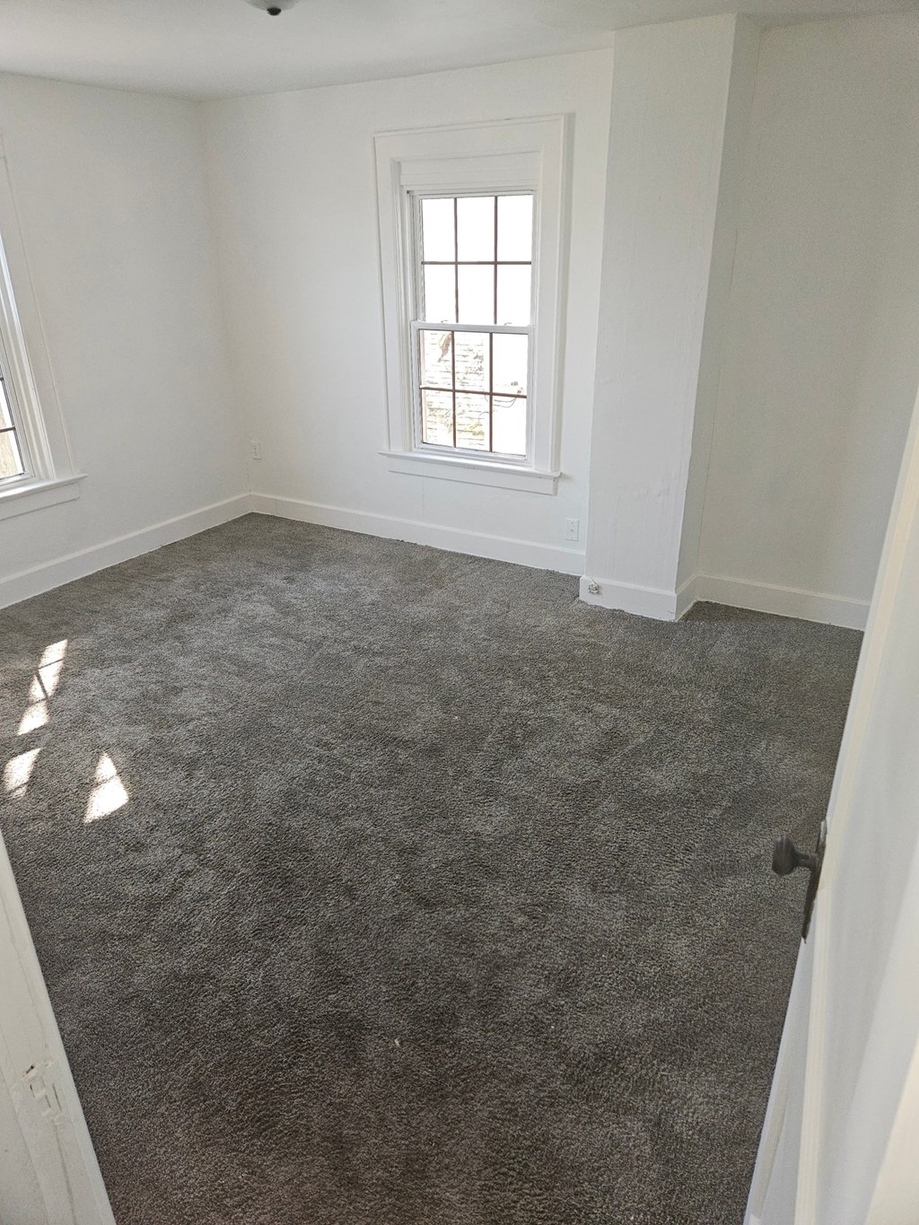 an empty room with a carpeted floor and a window