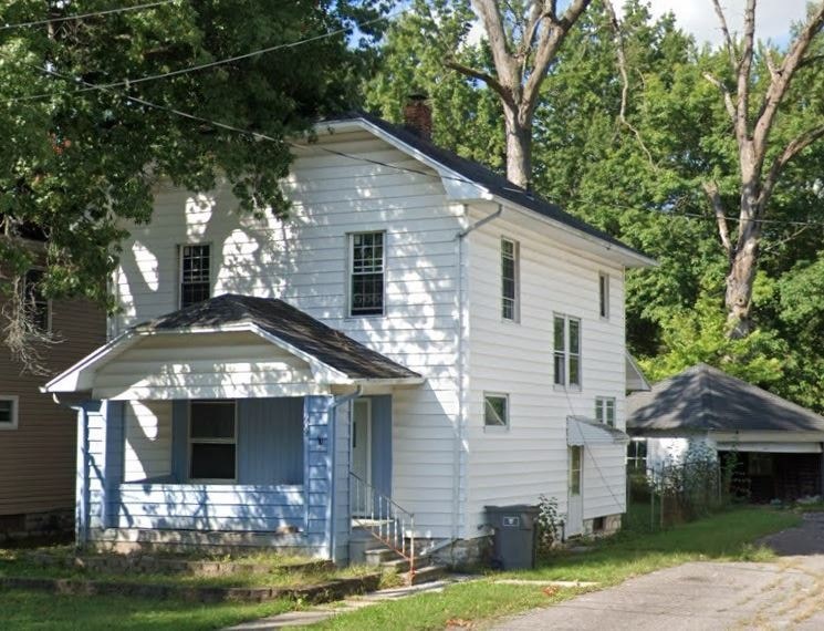 a white house with a blue door and a sidewalk